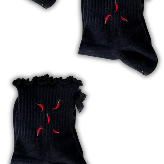 Black ruffle non slip grip sock with red chili pepper embroidered on them and black heart grips and a black bow